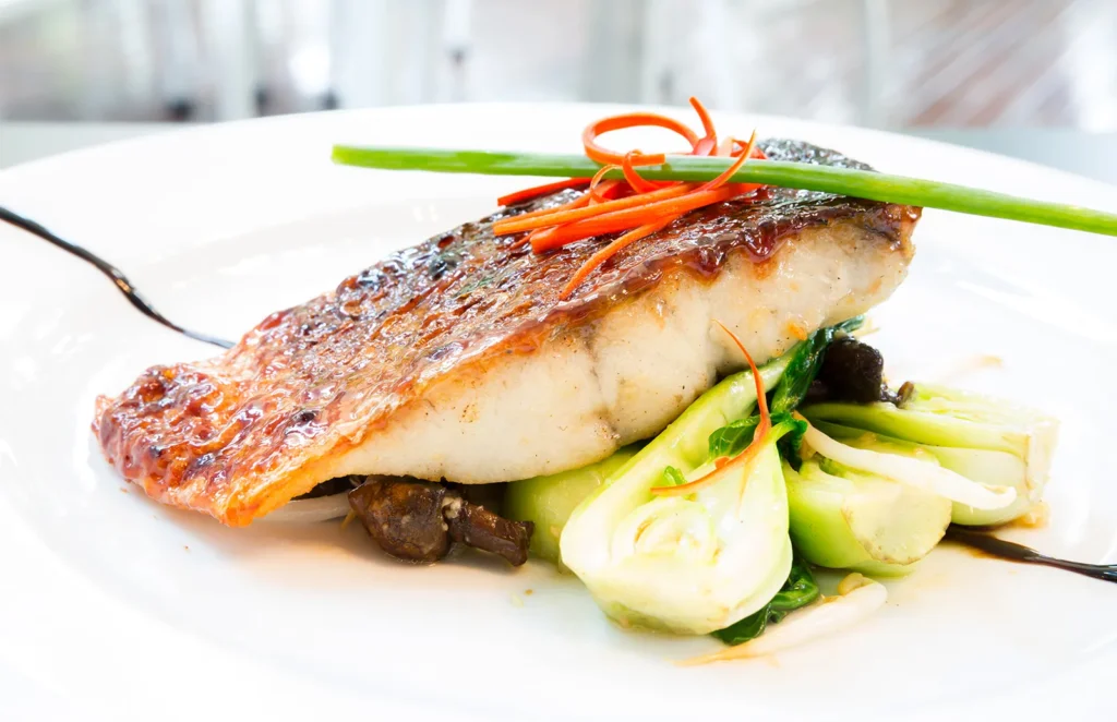 Grilled-barramundi-steak-on-a-bed-of-vegetables-vietnam-fishing-tour-trip-travel-in-summer-2026