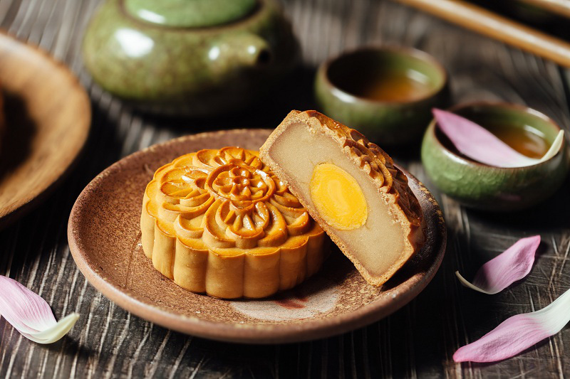 Enjoying mooncakes and tea during the Mid-Autumn Festival reunion.