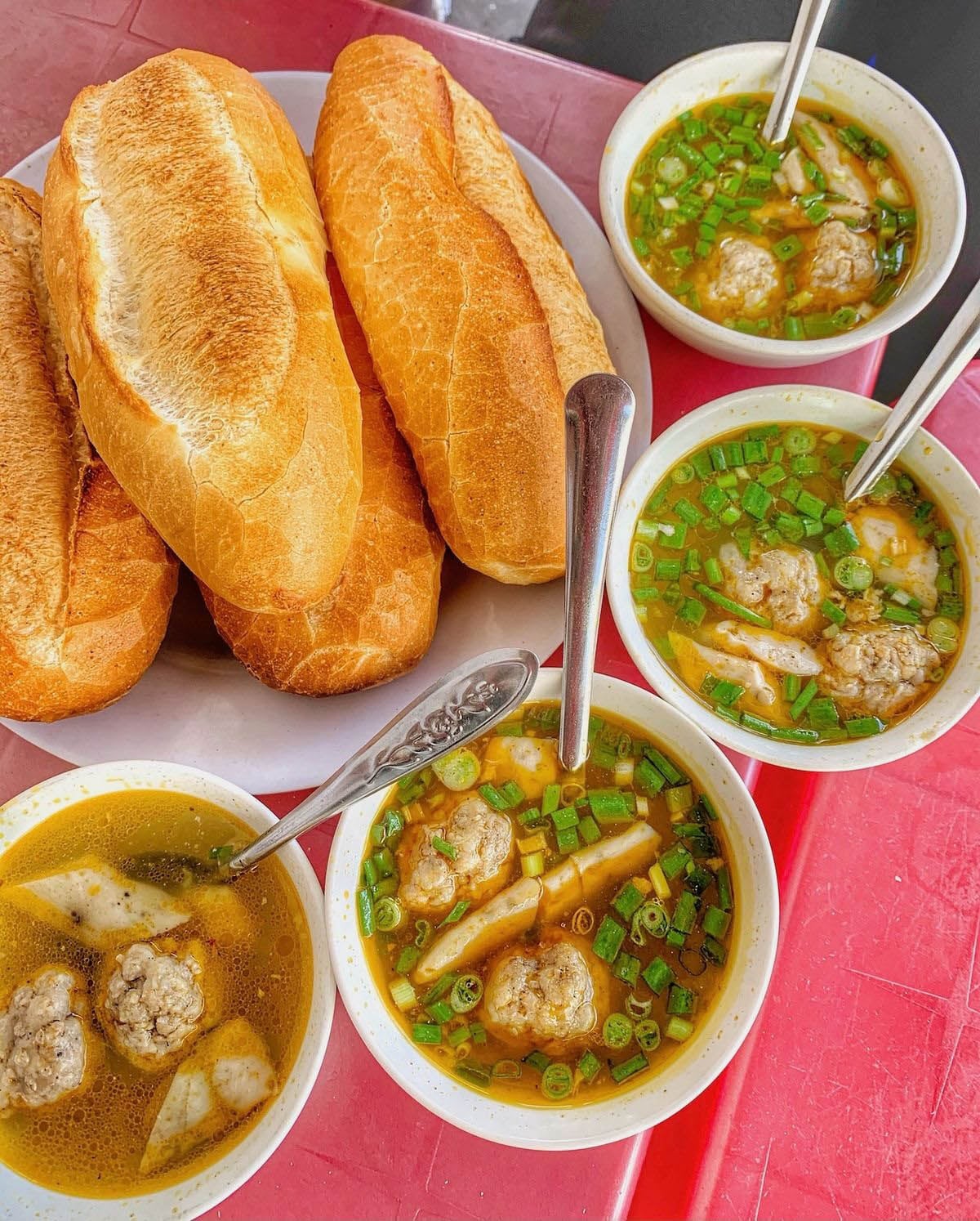 Da Lat-style bánh mì xíu mại is a renowned specialty featuring tender, aromatic meatballs and a subtly sweet broth made from pork bones and skin, served with crispy bánh mì and a touch of spicy sa tế (chili oil).